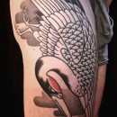 Japanese style tattoo of crane bird on thigh with red head and black and grey body and feather with soft grey background