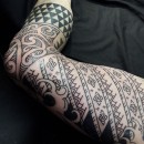 Mixed influence Polynesian style pattern work leg sleeve with sharktooth pattern and Maori designs and North African pattern work and also Japanese style black and grey waves on top of thigh
