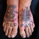 two tattooed feet saying the words hold fast with an anchor and a nautical star